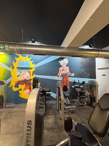 Saiyan Gym unutrašnjost — zidni mural s Goku likovima iznad sprava za trening