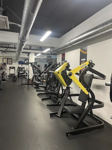 Saiyan Gym unutrašnjost — red crno-žutih sprava za trening snage